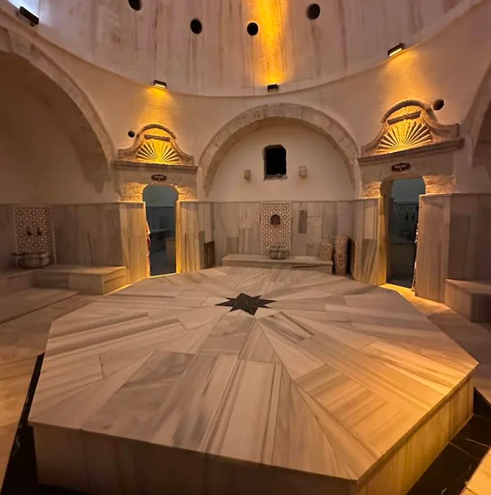Octagonal marble göbek taşı in the warmly illuminated hot room of Ürgüp Hamam.