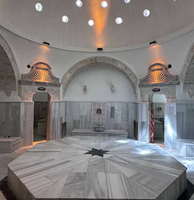 Daylight entering through circular openings in the hot-room dome above the göbek taşı.