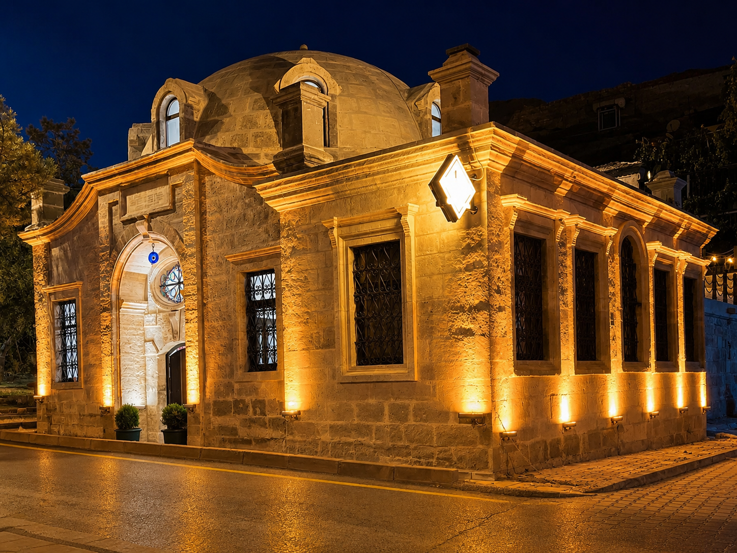 Wide night view of the illuminated Ürgüp Hamam dome and cut-stone entrance.