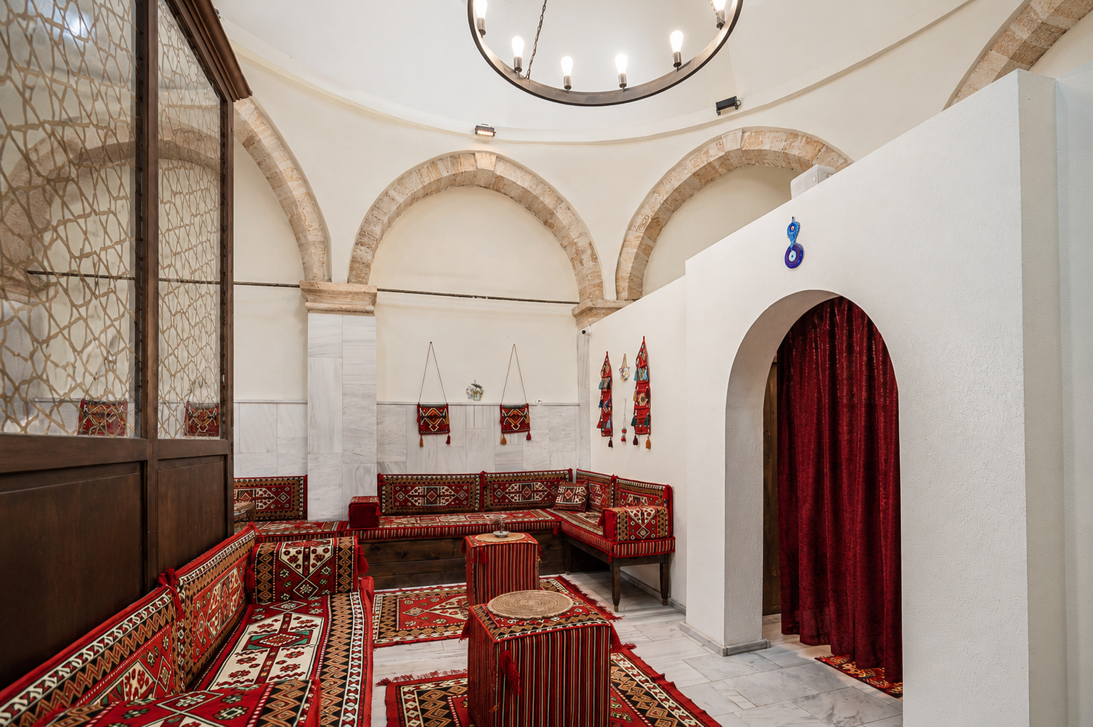 Traditional resting area with arches, textiles and seating inside Ürgüp Hamam.